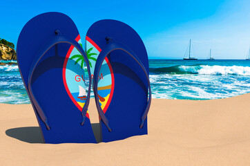 Flip flops with Guamanian flag on the beach. Guam resorts, vacation, tours, travel packages concept. 3D rendering