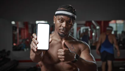 Fotobehang Persoonlijk African american guy showing phone with blank screen, copy space for ad. Gym workout and sports app for exercising  © Georgii