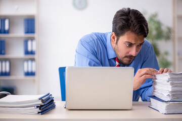 Young male employee unhappy with excessive work in the office