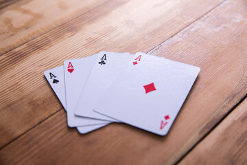 Four aces on wooden background