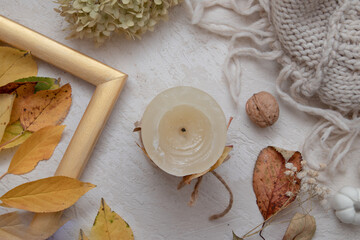 Autumn vintage still life top view with fallen leaves, dry rose, candles and knitted blanket. Autumn atmosphere concept