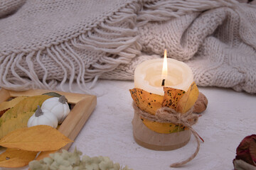 Obraz na płótnie Canvas Autumn vintage still life with fallen leaves, candles and a knitted blanket. Autumn atmosphere concept