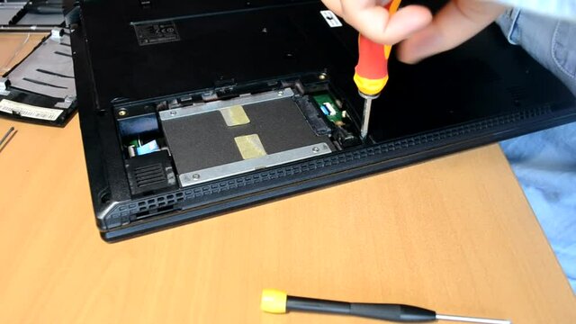 the wizard tightens the screw of the SSD drive in the laptop. Repair and service of laptops and computers.