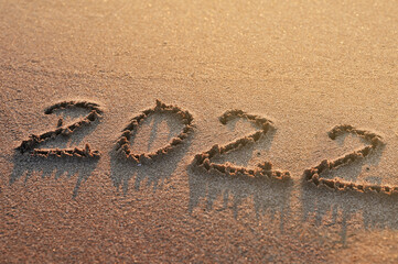 2022 written on sand texture. New year 2022 concept.