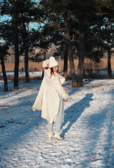 HAppy jumping woman has fun in forest in snowy weather. Winter holidays concept. Winter 2022.