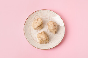 Plate with tasty dumplings on color background