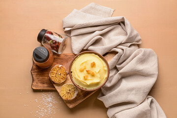 Bowl of tasty mashed potatoes with garlic on color wooden background