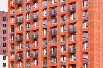 Fototapeta na wymiar Exterior of the red new apartment building after construction.