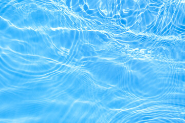 Surface of blue swimming pool water with light reflection. Texture of transparent blue water with waves in swimming pool. Trendy abstract nature background