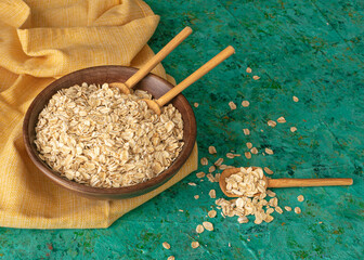 dry oatmeal in a bowl on rustic table 