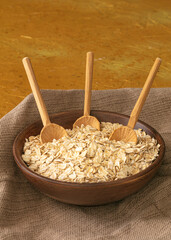 dry oatmeal in a bowl on rustic table 