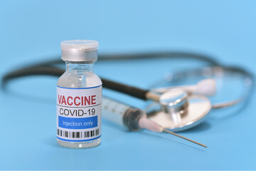 Coronavirus with syringe and stethoscope on blue background