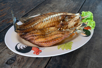 deep-fried sea bass fish on wooden table, Thai seafood menu 