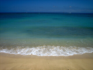 Fototapeta na wymiar Beautiful Blue Calm Lapping Ocean on Golden Sand