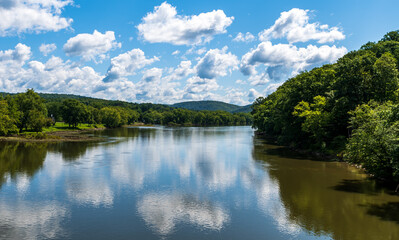 Obraz premium Clouds reflecting up on the Allegheny river in Tidioute, Pennsylvania, USA on a sunny summer day