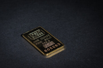 An ingot of pure gold on a black background.