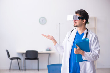 Young male doctor wearing virtual glasses in the clinic