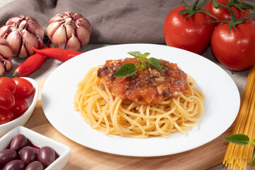 Spaghetti a la putanesca on white plate.