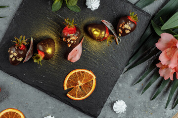 Fresh chocolate covered strawberries on a gray decorative background. Concept for advertising the summer seasonal menu