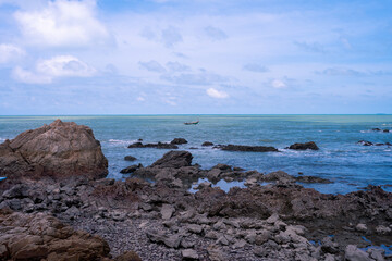 rock beach with blue sea view and bright cloudy blue sky at Ban Hua Laem village in Chanthaburi, Thailand