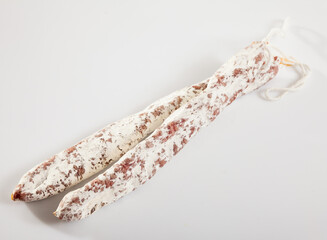 Close-up of spiced spanish fuet sausages at white background, nobody