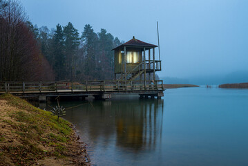 Fototapeta na wymiar A pier on the Beloye lake in Belarus on a foggy autumn morning