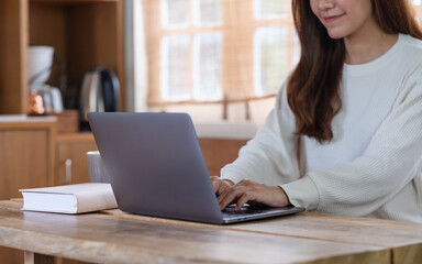 Closeup image of a beautiful young asian woman freelancer using laptop computer for working online at home