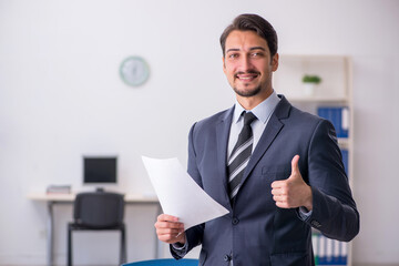 Young male employee sitting at workplace