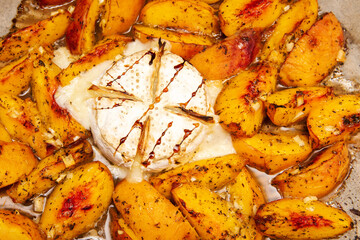 Baked brie cheese with peaches and honey. Gourmet food background 