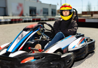 Happy positive smiling female go-cart racer at kart circuit outdoors