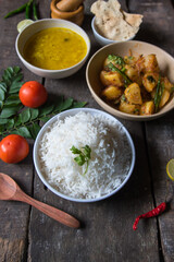 Cooked Indian food items rice, potato fry and dal background. Close up, selective focus.
