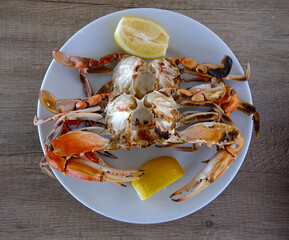blue crabs food with lemon slice on a wooden table.