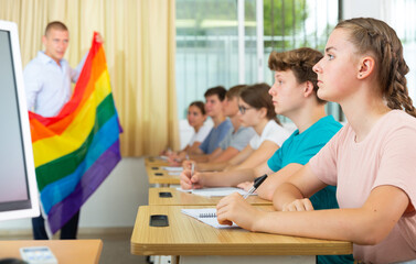 Pupils in classroom listen to the teacher who explains what is LGBT