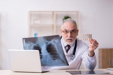 Old male doctor radiologist working in the clinic