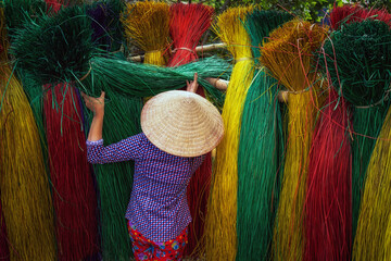 Back side of Vietnamese female craftsman drying traditional vietnam mats in the old traditional...