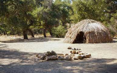 Historical Native American Indian Chumash village with homes and frames in woods with Oak Trees