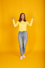 a young beautiful blonde girl in a yellow jacket and jeans holds a pose in full-length movement
