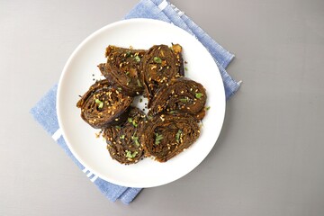 Alu Vadi, Patra, paatra, colocasia leaves roll, Patrode is a popular Indian healthy steamed snack. Garnished with sesame and mustard seeds. copy space.