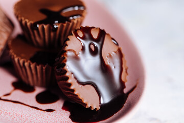 Chocolate pralines with flowers in background on a pink plate 