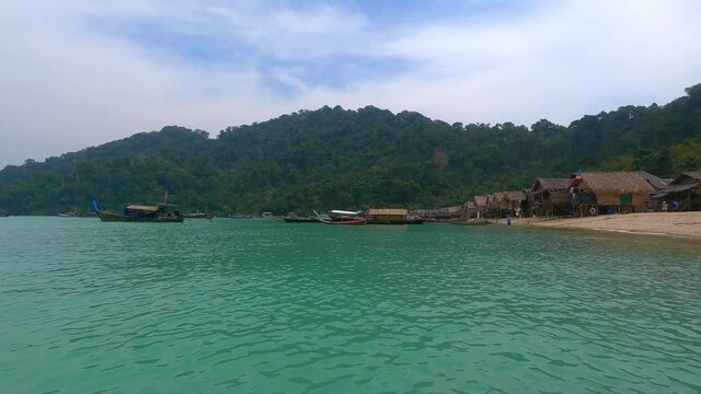 Landscape view of fishing longtail boat and Wooden hut in Morgan Village on Mu Ko Surin Island National park, Thailand.