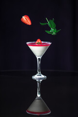 Panna Cotta with strawberry cream isolated on a dark black background