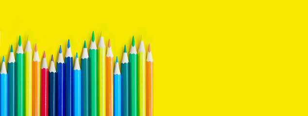 pencils on yellow background with copy space. School and creative painting concept with colored pencils. Back to school banner.