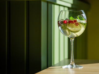 Refreshing summer drink cocktail with alcohol and ice on interior cafe or bar background with natural sun light 