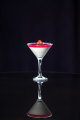 Panna Cotta with strawberry cream isolated on a dark black background