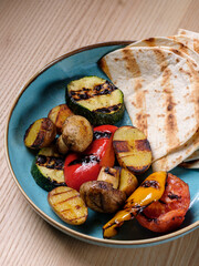 Grilled Vegetables from organic farm. Vegetarian barbecue garnish plate on wooden rustic table. Top view, copy space, selective focus.