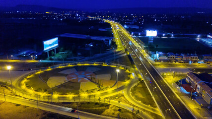 Fototapeta na wymiar Twilight brightly illuminated traffic intersection, roads and bridges at night view from above
