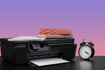 Home laser printer on desk against purple background