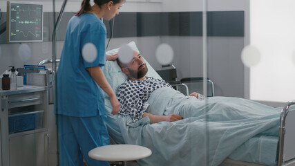 Sick man resting in bed wearing nasal oygen tube waiting practitioner doctor for disease...