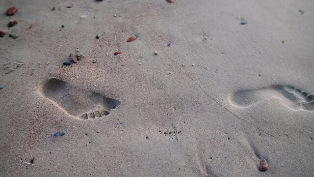 Closeup view of footprints on the  sand at beach.