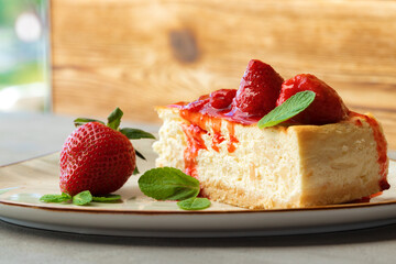 Piece of homemade strawberry cheesecake on white plate